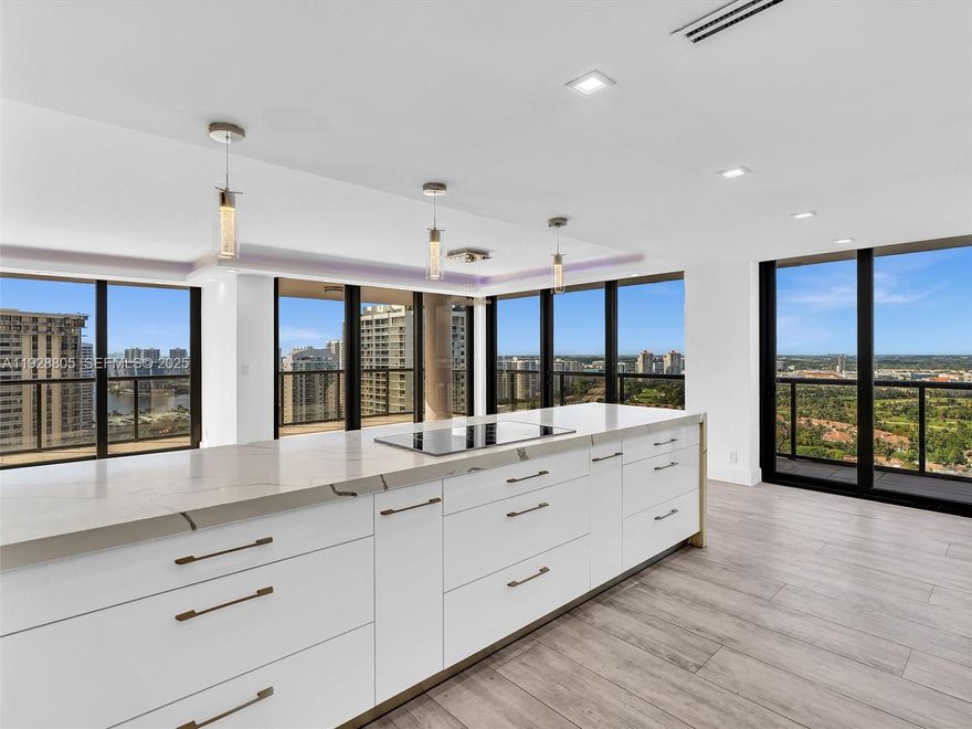 Beautifully renovated and oversized 2-bedroom, 2-bath corner residence with spectacular 360° views from sunrise to sunset. The modern open kitchen features high-gloss cabinetry, premium stainless-steel appliances, quartz waterfall counters, a full-height designer backsplash, home bar with wine cooler, built-in coffee system, and double ovens—perfect for everyday living and entertaining.
The expansive living and dining areas are wrapped in floor-to-ceiling impact glass windows, opening to a deep wraparound balcony with panoramic ocean, city, and golf course views.
The primary suite offers a spa-quality retreat with a large walk-in shower, freestanding soaking tub, double vanity, and an impressive boutique-style walk-in closet with center island and chandelier.
The building features a resort-style pool, fitness center, updated lobby, valet, concierge, and 24-hour security. Ideally located in the heart of Aventura, just moments from premier shopping, dining, marinas, and houses of worship.