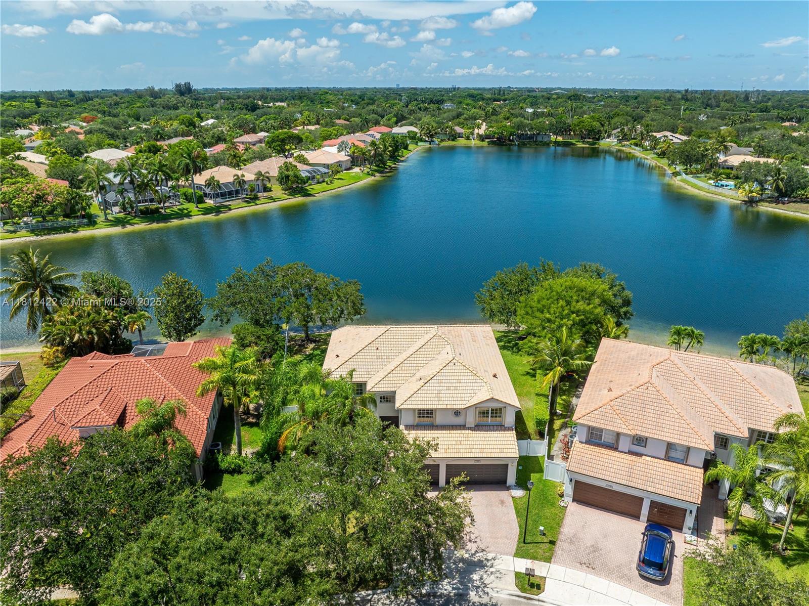 DISCOVER THE JOY OF COMING HOME TO SWEEPING LAKE VIEWS IN PEMBROKE FALLS * THIS GRAND CAYMAN MODEL WITH 5 BED, 4 BATH SITS ON A PIE-SHAPED LOT WITH 120 FT OF WATER FRONTAGE—A RARE FIND! RELAX UNDER YOUR CUSTOM EXTENDED COVERED PATIO WITH RETRACTABLE SCREENS - PERFECT FOR ENTERTAINING * ENJOY PEACE OF MIND DURING ANY STORM WITH A WHOLE HOME GENERATOR, PARTIAL IMPACT WINDOWS & ACCORDION SHUTTERS * THE SOARING 20-FOOT CEILINGS FILL THE OPEN CONCEPT KITCHEN & FAMILY ROOM WITH NATURAL LIGHT & ENERGY * THE OVERSIZED PRIMARY SUITE OFFERS A SITTING AREA, 2 WALK-IN CALIFORNIA CLOSETS & AN ADDITIONAL 3RD CLOSET * A SECONDARY BEDROOM & BATHROOM LOCATED ON THE FIRST FLOOR * COMMUNITY AMENITIES INCLUDE A RESORT-STYLE CLUBHOUSE, NATURAL GAS & MORE * HOA INCLUDES CABLE, INTERNET, 24HR SECURITY & MORE!