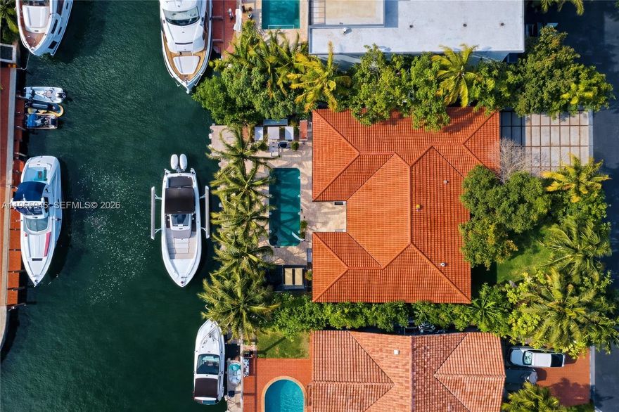 Modern waterfront residence in the guard-gated community of Eastern Shores offering 80 feet of deep-water frontage with direct ocean and bay access and no fixed bridges. This single-story 4-bedroom, 4-bath home features a bright split floor plan with polished concrete floors and floor-to-ceiling impact sliding doors creating seamless indoor-outdoor living. Southern exposure fills the interiors with natural light throughout the day.

The open kitchen is centered around an oversized island and equipped with a Wolf gas cooktop and premium appliances, all overlooking the pool and canal. The primary suite occupies its own private wing and includes a spa-style bath with an oversized walk-in shower and generous proportions.

Outdoor spaces are designed for true waterfront living, featuring a heated pool, in-ground spa, mature tropical landscaping, ambient lighting, and multiple lounge and entertaining areas. The 80-foot dock includes a 16,000 lb boat lift plus additional jet ski dock, offering easy maneuverability and quick access to open water.

Additional highlights include full impact glass, updated systems, concrete driveway, and a two-car garage with custom flooring and built-in storage. Ideally located just minutes from Sunny Isles Beach, Aventura Mall, Oleta River State Park, dining, and shopping. A rare opportunity to secure a move-in-ready waterfront home in one of North Miami Beach’s most desirable gated communities.