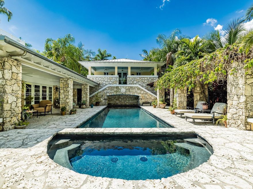 "Coral Brook" a timeless architectural design on over 1/2 acre is surrounded by tropical gardens! Gated entry grants access to this coral rock paradise. Meticulously remodeled & restored provides modern updates & classic, historical feels. French doors welcome you to living areas in main home. Exotic hardwood floors, coral rock Fireplace & soapstone counters set this home apart. 3 bedrooms on ground floor w/ 2 baths. Primary suite upstairs w/ luxurious bath, walk-in closets, & access to roof top Captain's Walk. Exquisite heated pool w/ waterfall & jacuzzi, screened porch & roof patio create backyard oasis. Oversized 2 car-garage offers cabana bath & guest quarters w/ balcony. 2 fountains feed the brook w/ covered courtyard patio round out this property. A rare & treasured oasis!