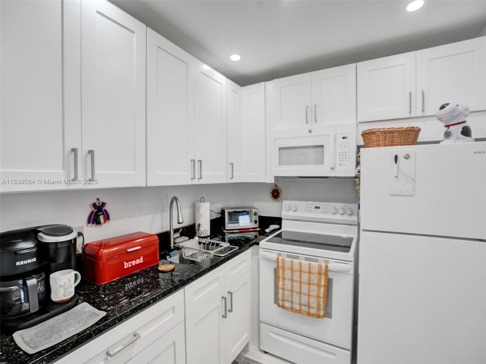 First floor condo located in an active 55+ gated community, with NEW renovated kitchen equipped with brand-NEW appliances, NEW water heater & NEW AC unit. Tile flooring through the entirety of the residence, & a recently freshly renovated bathroom. Enclosed balcony. Enjoy peace of mind with 24-hour manned security at the guard house. Community amenities available at the clubhouse: movie theater, shows, a fully equipped gym, and state-of-the-art facilities for pickleball, tennis, indoor/outdoor pools. Engage in a variety of activities, dance classes & other stimulating programs & classes offered on-site. Convenient transportation services to & from the community ensure ease of access, while proximity to shopping adds further convenience to this desirable location. One assigned parking.