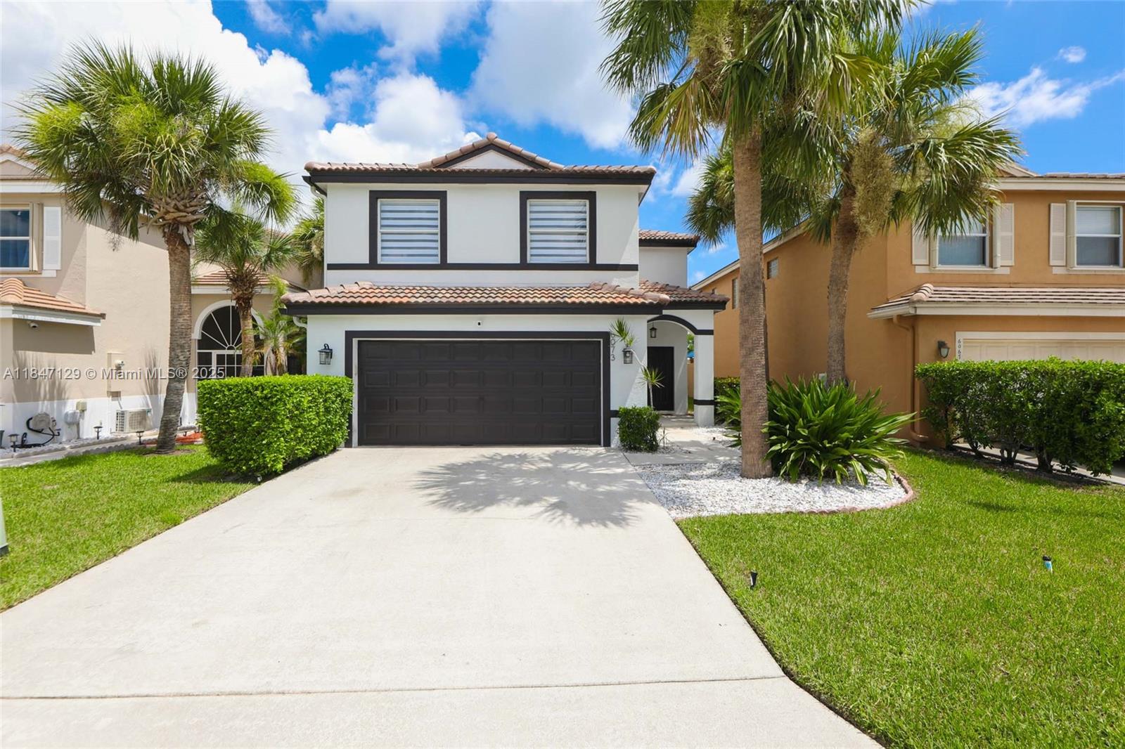 Stunning transformation! Over $150,000 OF UPGRADES IN 2025: 3/2.5, 2 car garage home in quiet & beautiful gated community of "The Springs". Serene lake views & access to top-rated schools. Updates include new roof, AC, interior/exterior paint, recessed lighting, new sprinklers, Porcelain slab on TV wall. Kitchen has soft-close cabinets, marble backsplash w/brass design & extended quartz countertops. Bathrooms redone; high end porcelain tile floors throughout. Features high ceilings with twin glass chandeliers in living/dining area, artist mural, new appliances (except fridge), honeycomb blinds, new sod, mango trees, covered patio, new garage motor, and separate laundry room. Community pool & kid's playground on premises. Free basic cable, lawn service and MORE. Don't miss this opportunity!