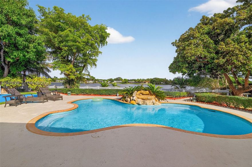 Lakefront living in the heart of Kendall. Situated on a rare 15,000 SF lot within an exclusive private lake community of only 37 homes, this gated residence offers a unique blend of privacy, space, and convenience directly across from Baptist Hospital. Featuring 3 bedrooms, 3 bathrooms, and approximately 2,884 SF of living area, the home showcases a spacious split-floor plan with an office, expansive living areas, and a large Florida room with tranquil water views. Designed for both entertaining and everyday living, the outdoor spaces include a resort-style pool with rock waterfall feature, tropical landscaping, lakeside seating areas, and a versatile sport/pickleball pad. The kitchen features white cabinetry, granite countertops, stainless steel appliances, and a bright breakfast area. The oversized primary suite offers a spa-inspired bathroom with jacuzzi tub, rainfall shower, and custom walk-in closet. Additional highlights include a 2012 roof, two A/C units (2020 & 2025), circular driveway, gated entry, and parking on both sides of the property. Homes on this lake rarely become available. An exceptional opportunity for buyers seeking a private waterfront lifestyle with close proximity to top-rated schools, major highways, dining, shopping, and some of Miami’s leading medical facilities.
