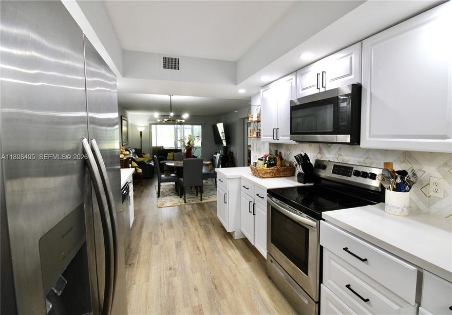 Move in ready !Renovated, Just bring your clothes! This beautifully refreshed first-floor home has No popcorn ceilings & the convenience of assigned parking just steps from your front door—truly one of Century Village’s most desirable locations. Step into a bright white kitchen featuring newer appliances and quartz countertops. Enjoy the ease of having your own washer and dryer, plus a tankless water heater. The glass-enclosed terrace offers peaceful golf and water views, perfect for unwinding any time of day. Both the primary and 2nd bedrooms include walk-in closets. The primary bath features an updated shower and a double-sink vanity. Hall bath also updated. Lots of space 1351sf .Century Village living means world-class amenities: a stunning clubhouse, movie theater, grand ballroom, indoor and outdoor heated pools, pickleball and tennis courts, a house of worship, and top-tier shows. This vibrant 55+ community also provides transportation to shopping and medical facilities. No rental restrictions. Can be rented after closing. Live your best life here!