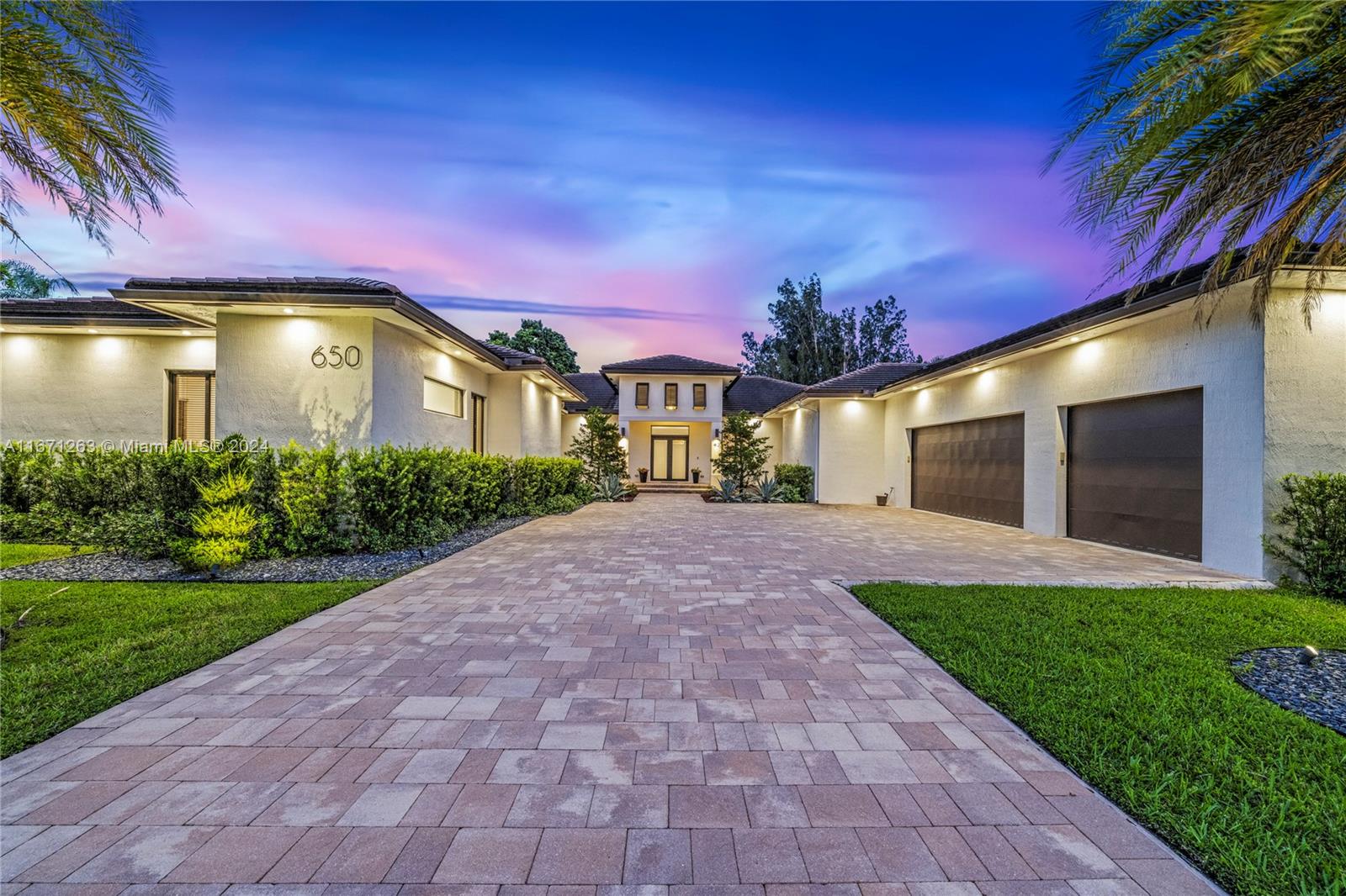Step into modern elegance with this 2020-built, single-story luxury home, offering 5 spacious bedrooms, each with its own en-suite bathroom, plus a stylish half-bath. The open layout boasts sleek, massive porcelain floors throughout, while the chef’s kitchen features top-of-the-line appliances, perfect for culinary enthusiasts. A grand entrance welcomes you to a private oasis with meticulously designed landscaping. The expansive covered terrace, complete with a fully equipped summer kitchen, is ideal for entertaining. A 3-car garage with EV charging provides convenience, and the home’s clean, contemporary architecture creates an effortlessly stylish ambiance. This stunning property offers privacy, modern amenities, and sophisticated living at its finest. You will love this home! Walk to AH