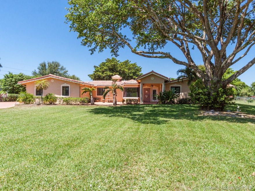 Major price reduction.Welcome Home! Peace and tranquility will be yours as you enter the gates of this 1 acre estate through the massive driveway. Bring your horses and RV and boat. Spacious 5/3 with 5 car garage features a formal living and dining room & large Florida room. Remodeled kitchen with granite counters and updated appliances. Master bathroom has Jacuzzi bath and separate shower with his & her sinks. Most windows and doors are impact. Tons of closets. Covered, tiled, screened (back)patio with ceiling fans overlooks the gorgeous backyard, large pond and Jacuzzi (as is) surrounded by a wood deck. Charming front patio. Generac whole house generator included in the sale. Close to major access roads, shopping, restaurants, air port & more.