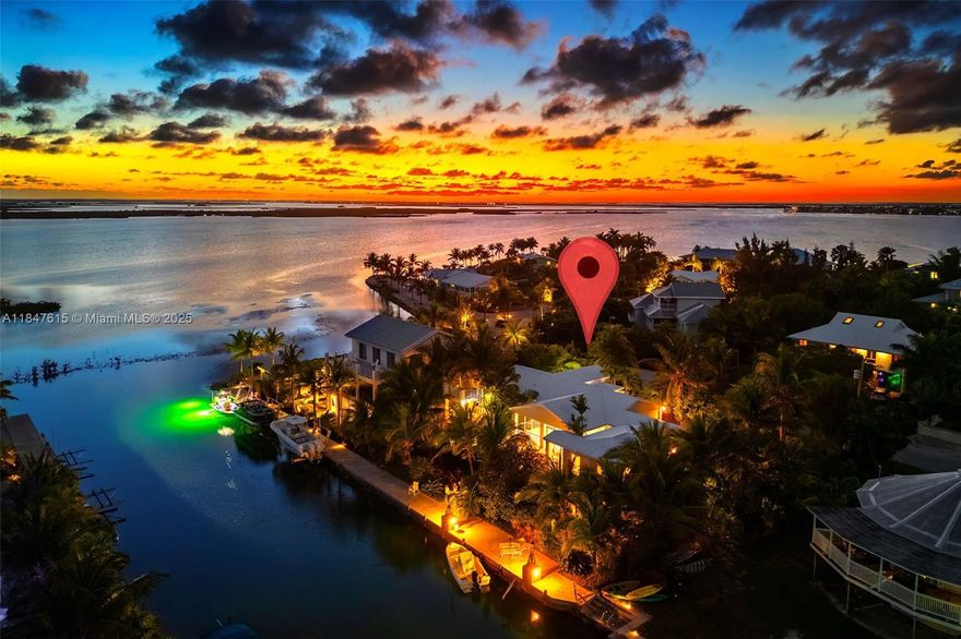Waterfront retreat in prestigious Sugarloaf Key, just 20 mins from Key West! This 4BD/3BA home sits on a 12,500 sq ft lot with 100' of seawall, davits, and wide canal access—just one in from open water. Enjoy a split-bedroom layout with two primary suites, an open kitchen with stainless appliances, and a theater room. Outdoor living shines with covered entertaining space, custom bar, fire pit, rooftop terrace, screened porch, and a unique outdoor shower crafted from a Key West ticket booth. Lush landscaping offers privacy, with plenty of room for a pool. Garage, covered parking, and circular drive included. Ideal for boaters and nature lovers alike!