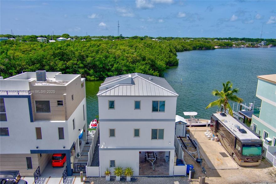 This stunning three-story waterfront home offers panoramic ocean views from every level and a private elevator for effortless access. The outdoor entertainment area features a covered summer kitchen, dining space, and lounge area perfect for hosting or relaxing by the water. Boaters will love two lifts—28ft on the lift and 35ft in the water next to it. Inside, enjoy impact windows and doors, quartz countertops, stainless steel appliances, and a Bluetooth sound system throughout. Experience the Calusa Island lifestyle—fish, boat, paddleboard, or enjoy endless sunsets. A rare 2-day minimum rental in Islamorada, this property is a verified income generator and a true boater’s paradise, offering the perfect blend of waterfront luxury and high-performing investment potential.