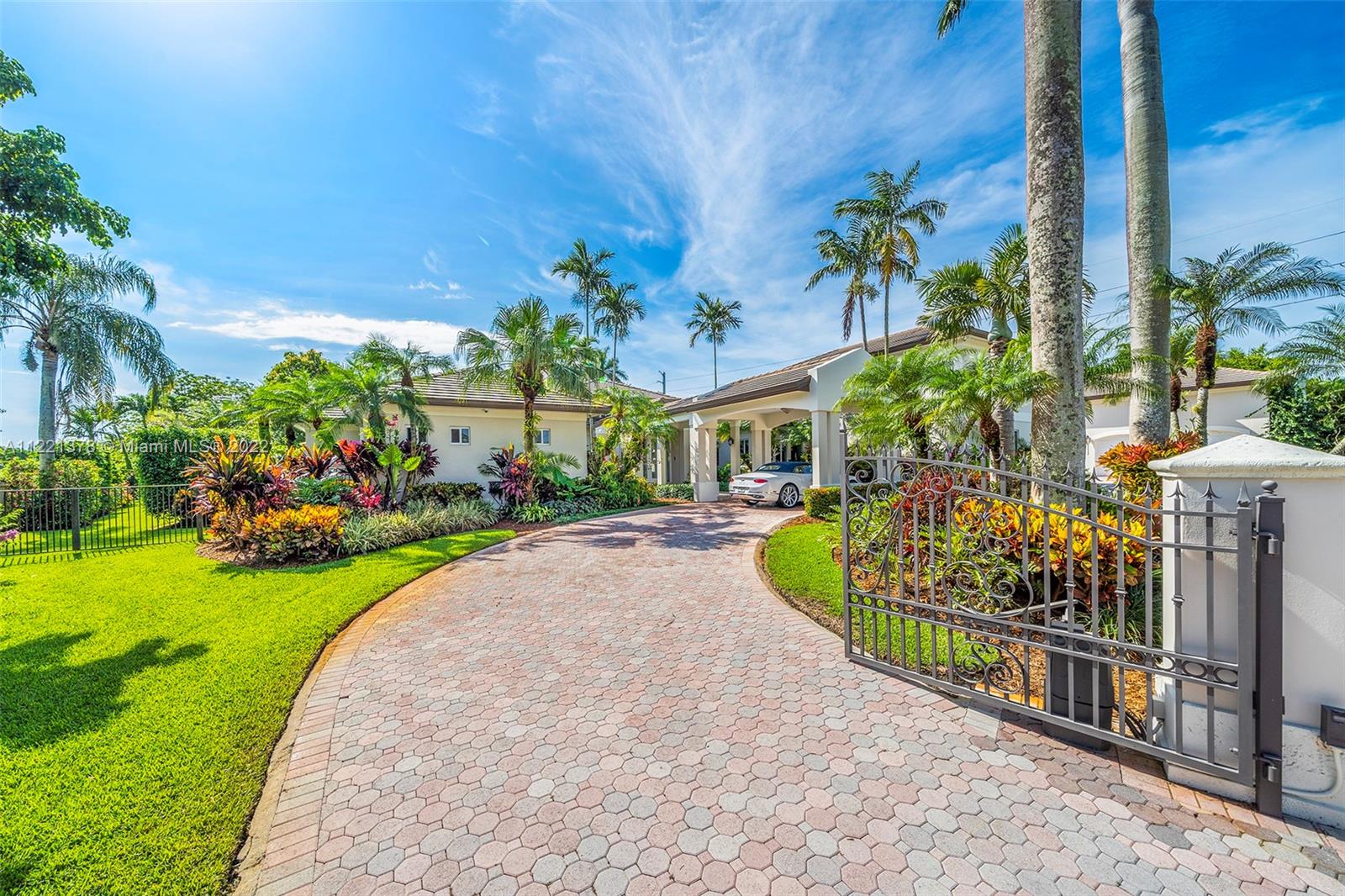 Discover this compound on a cul-de-sac near Baptist Hospital complete with 7 door 15 car air conditioned garage with automatic lifts. This estate suits a multi-generational family with 5/5 in the main home plus a full 2/2 apartment featuring a living room, & kitchen. The master suite overlooks the landscaped gardens & boasts fine finishes, high ceilings, artfully appointed walk-in closets, separate gym and magnificent onyx bathroom with double sinks, spa tub & shower. Live & entertain indoors and out with a theatre that seats 11, a walk-in 500 bottle wine cellar & bar, billiard room, tennis court, pool, & patio with summer kitchen. A tropical oasis with landscaping of varied blooms and assortment of mature palms that frame this extraordinary 53,291 sf lot.