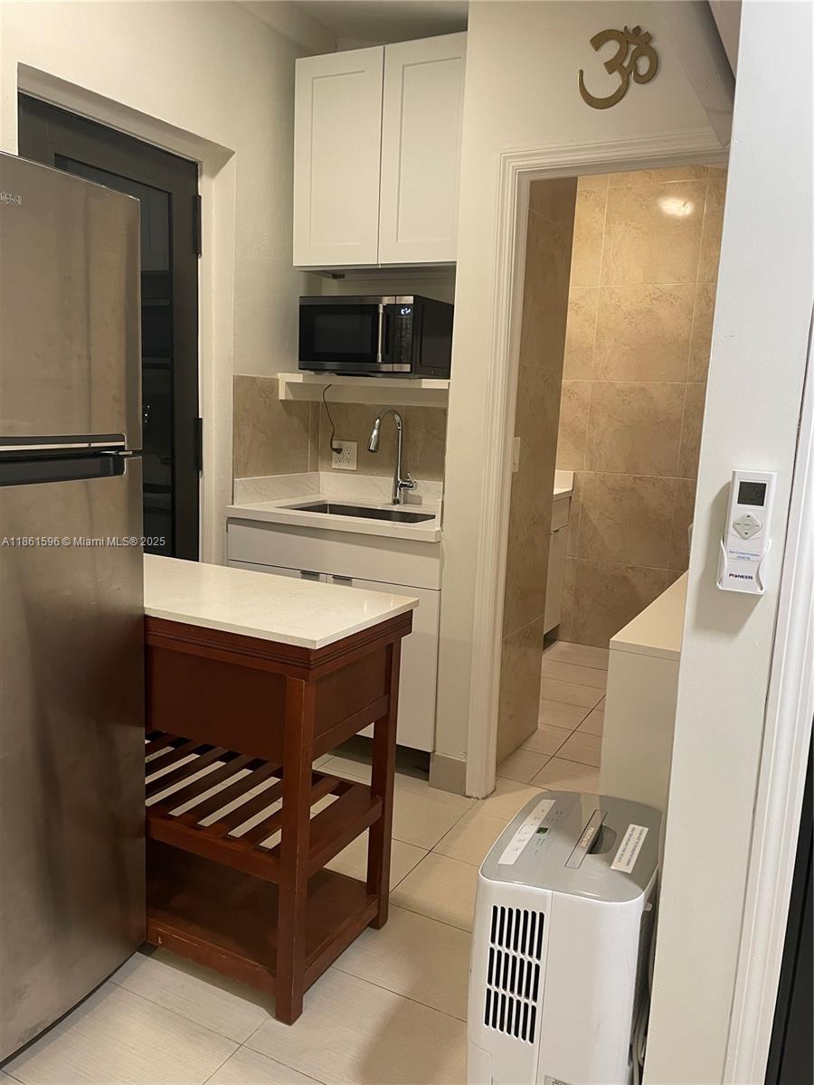 This furnished studio with separate access is part of a single-family house. It includes a kitchenette and a full bathroom. Shared Laundry set