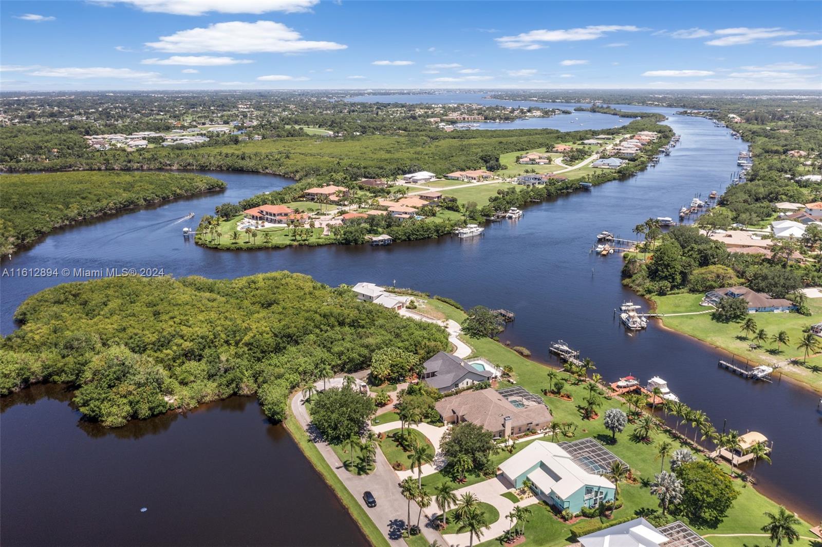 Welcome to your unique mini-sized estate on a picturesque peninsula, where luxury meets tranquility on the mile and a half view down deep water of the North Fork Saint Lucie River with ocean access. This stunning property boasts a 65-foot dock with a boat lift capable of accommodating a 26-foot boat, as well as space for your "YACHT" and other water toys, drawing no less than 7 1/2 feet of water. Each room in this meticulously updated home offers breathtaking water views, complemented by voluminous ceilings that create an open and airy atmosphere. From high-end finishes and materials to a 3 1/2 plus garage with A/C hookup and two ceiling fans, every detail has been carefully considered to provide the ultimate in comfort and luxury living.