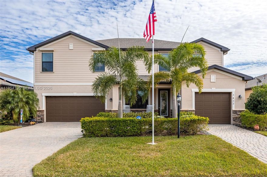 This striking lakefront home in Portico impresses from the moment you walk in and continues to impress daily. Set on one of the community’s most breathtaking long-lake lots, this five-bedroom plus loft, four-and-a-half-bath pool home offers space, flexibility, and stunning water views from sunrise to sunset. Built in 2021, the Sorrento floor plan features an open main level with wood-look tile, crown molding, and a central kitchen with white cabinetry, granite counters, stainless appliances, extended dining cabinetry, and a wine cooler. A full first-floor guest suite with pool access is perfect for guests or multigenerational living. Outside, the oversized lanai with custom pavers overlooks the heated pool and wide water views, with motorized hurricane-rated Kevlar screens. Upstairs, four bedrooms and a flexible loft add space, while upgrades like epoxy garage floors, insulated doors, whole-house water softener, and designer lighting enhance move-in readiness. Located in an X flood zone requiring no flood insurance and equipped with impact-rated windows and shutters, this gated Portico home offers peace of mind and access to a clubhouse, pool, courts, fitness room and play are, all minutes from shopping and dining.