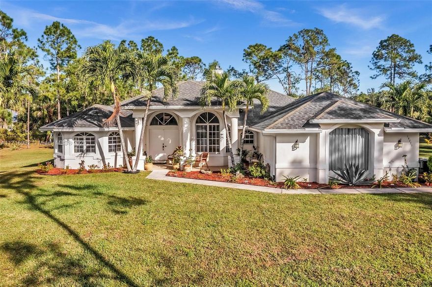 Nestled on over an acre of greenery in The Acreage, this Palm Beach estate offers spacious living and endless possibilities to create your dream oasis. It features 4 bedrooms, 3 bathrooms, an office/exercise room, and a cozy wood-burning fireplace, with volume ceilings enhancing its airy feel. The master suite opens onto a screened lanai, while the kitchen, with an island and breakfast nook, flows into a large family/game room. Solar panels provide energy savings ($194 a month leased), and the property is pre-wired for a pool. The expansive grounds offer room for a pool, outdoor kitchen, or parking for boats/vehicles, plus space for gardening or other projects. Fruit trees add natural charm to this serene property. Roof being replaced!