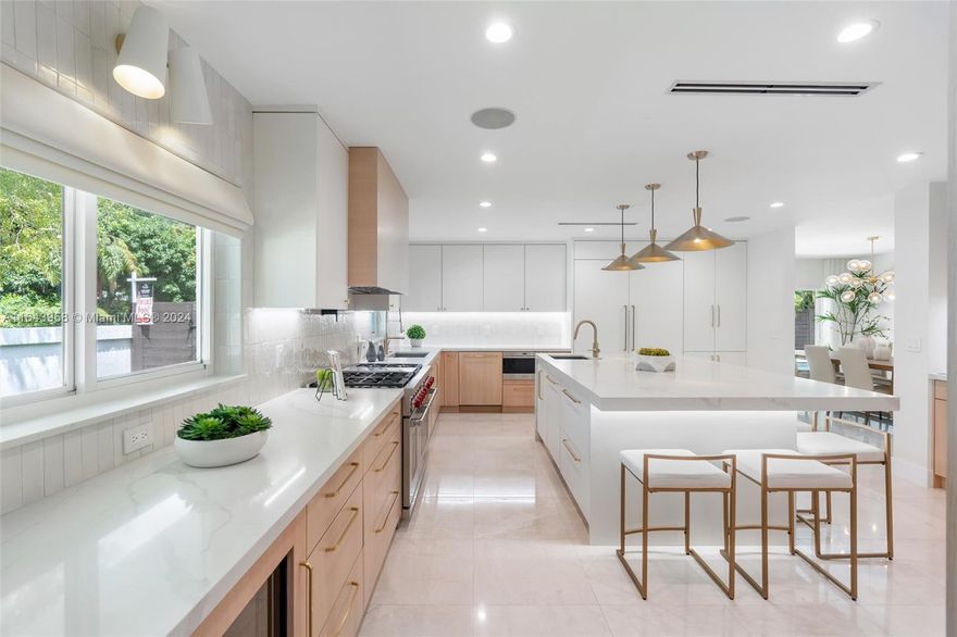 Gorgeous Large (3255 sq ft) East Miami Shores Pool Home on large corner lot, blocks from Biscayne Bay! Spacious 4 bedrooms, with a den (5 bedrooms), a new Gourmet Kitchen in 2023 with top-of-the-line Sub-Zero & Wolf appliances, coffee station, 2 dishwashers, 2 sinks, & 2 wine coolers. An oversized Quartz island seats 6, perfect for cooking & entertaining. Also featuring marble flooring, full house natural gas generator, updated plumbing & electric, 2023 AC system, impact windows/ added pane for sound barrier, mosquito system, int/ext sound system & alarm/ HD cameras. The backyard is a spa oasis featuring a heated saltwater pool &  jacuzzi, a fully equipped outdoor kitchen with a Blaze BBQ, sink, and fridge, & 2 outdoor TV areas, ideal for entertaining, PLUS large 2.5 car AC garage