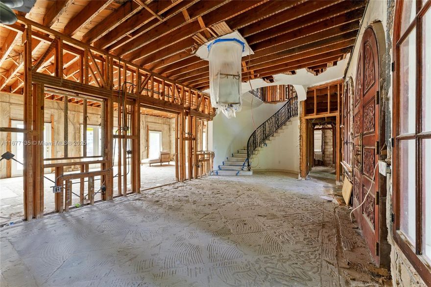 Imagine the endless possibilities with this picturesque waterfront estate on prestigious Pine Tree Dr. A lush garden courtyard sets the stage as you enter this grand residence with 76’ of prime waterfrontage and sparkling water views. Stripped down to its essence, this elegant home is a blank canvas, offering a rare opportunity to renovate & design your dream space while maintaining the estate's timeless architecture. Sunlight pours through expansive windows & soaring ceilings. Additional features include a new roof with handcrafted Spanish tiles, original plaster moldings, a grand spiral staircase, and private balconies extending from the bedrooms. Outside, a spacious pool & a private dock complete the setting for ultimate waterfront living.