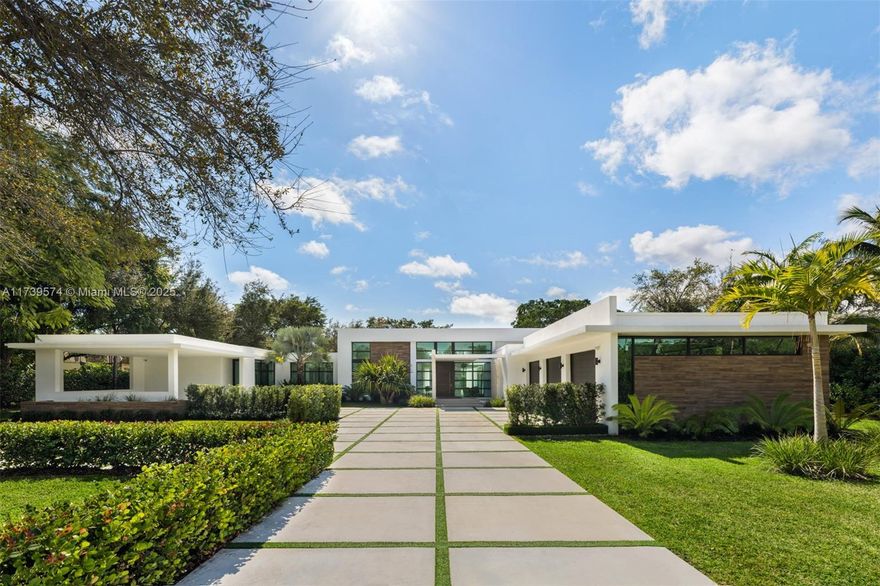 Experience unparalleled elegance in this exquisite modern estate, built in 2022, nestled in Pinecrest. This residence welcomes you with captivating water elements and an expansive open layout featuring soaring ceilings and stunning panoramic vistas. This home offers 7 bedrooms and 7/1 bathrooms, including a detached 1-bedroom, 1-bathroom guest house. The Italian-inspired kitchen is a masterpiece, with Wolf and SubZero appliances, a wet bar, a butler’s pantry, and a glass-enclosed wine display. The primary suite features a cozy sitting area, walk-in closets, and a spa-inspired bathroom with a floating soaking tub and a rain shower. Step outside to a vast swimming pool, jacuzzi, covered terraces, and a summer kitchen. Additional highlights include a spacious 3-car garage, & a 2-car carport.