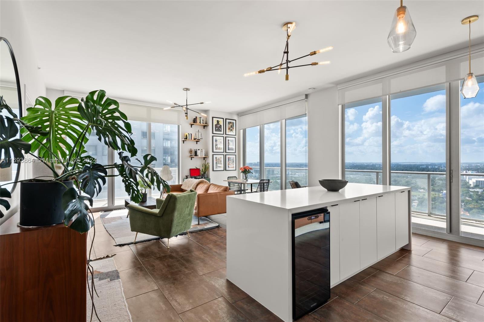 Experience the best of Miami in this beautifully renovated 2-bedroom, 2-bath residence on the 26th floor of coveted 2Midtown. Designed for those who value high-end finishes and expansive views, this condo features 10-ft ceilings, a sleek kitchen with a new island, wine cooler, premium appliances, and chic lighting. The open floor plan extends to a 569 SqFt wraparound terrace with stunning city and bay views. Designer touches include slate porcelain tiles, custom lighting, and modern finishes. Spacious bedrooms offer ample closets, and renovated bathrooms provide a luxurious touch. Enjoy amenities like a fitness center, pool, hot tub, sauna, playground, and outdoor lounge. Just steps from Wynwood and the Design District's dining, shopping, and culture.