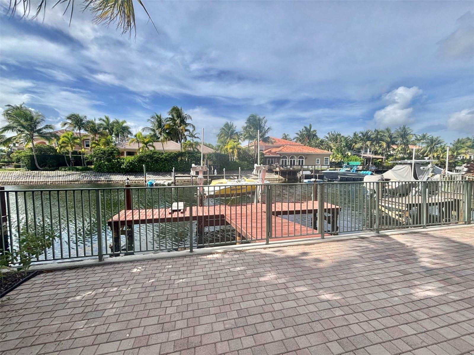 Welcome to a truly one-of-a-kind coastal retreat—this exceptional WATERFRONT 2 story estate, once owned by the legendary Joe DiMaggio, blends timeless prestige with modern luxury. Nestled in an exclusive GATED community, this 5/4 POOL home offers an unparalleled lifestyle with access to resort-style amenities including tennis courts, a resort-style community pool, state-of-the-art fitness center, private marina, 24 hour security, etc. The main residence features 4 spacious bedrooms & 3 full bathrooms. Adding to the appeal is a separate GUEST HOUSE with its own private bedroom & bathroom. The property also boasts a 3-car paved driveway and a rare PRIVATE 40ft BOAT DOCK with a 20,000 BOAT LIFT, making it a dream for boating enthusiasts!