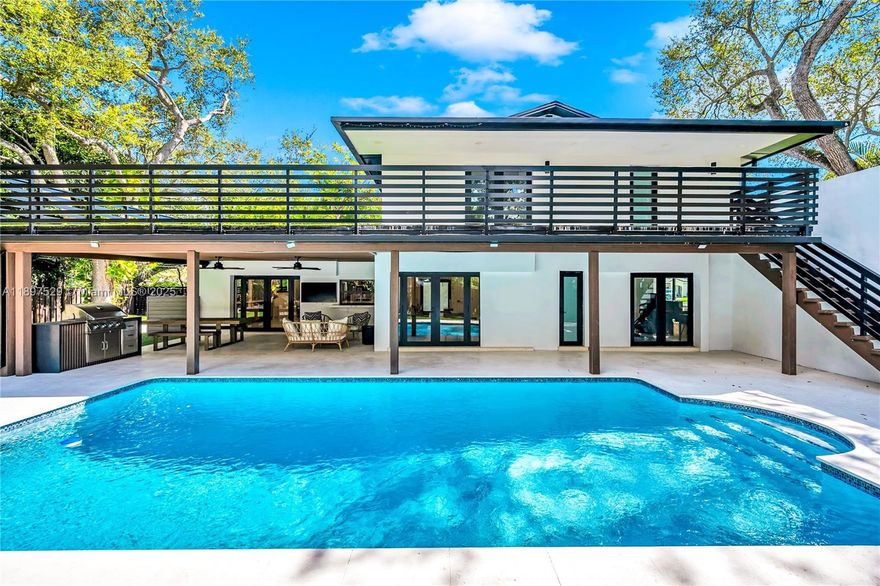 Perfectly positioned on a corner lot, this fully upgraded and meticulously maintained 5 bedroom, 3 bathroom residence blends contemporary design with effortless South Florida living. Every detail has been thoughtfully curated — Grohe fixtures and custom built-ins throughout, Bosch appliances, metal roof, impact windows, and Tesla charger. Resort-style living with a resurfaced and heated pool equipped with brand-new pool water heater, a stylish pergola, a full outdoor kitchen, and a rooftop terrace accessible from the backyard — all surrounded by lush turf and mature landscaping for total privacy. Two newly completed driveways and an oversized two-car garage provide ample parking and seamless functionality. Refined finishes, timeless design, and elevated indoor-outdoor living at every turn.