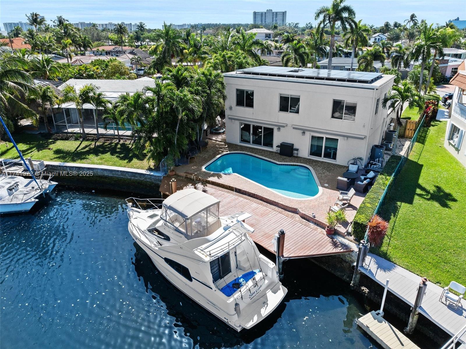 Discover coastal luxury in this spectacular waterfront oasis in Santa Barbara Shores! Boating enthusiasts will appreciate the 50-ft dock with ocean access and no fixed bridges, heated pool and beautiful water views. This 4 BR/3BA features 3,058 sq. ft. open and functional living space with master suite and one bedroom on the first floor and two additional bedrooms and versatile loft upstairs. Gourmet kitchen features wood cabinetry, quartz countertops, and stainless-steel appliances. Embrace modern efficiency with a 2021 roof, solar panels, impact windows/doors and Tesla charging station. Located just minutes from shopping, dining, and less than 10 minutes from the beach. Experience the best of South Florida living in this turnkey waterfront retreat, where luxury meets functionality!
