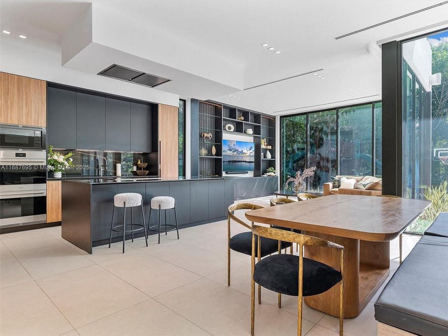 Nestled in the prestigious Miami Shores community, this turnkey masterpiece designed by SDH Studio epitomizes modern luxury and family-friendly living. Featuring seamless indoor and outdoor living: The first floor boasts 11-foot ceilings, a Living Room, Dining Room, Den, Powder Room, Office, and a Mia Cucina kitchen equipped with Wolf appliances, a Sub-Zero refrigerator, and a custom wine fridge, perfect for culinary activities and gatherings. Upstairs, four bedrooms with en suite bathrooms, a second den with a homework station, and a luxurious primary suite with a private deck await. This home offers discerning families a sophisticated yet comfortable lifestyle enriched with community and safety, country club amenities, a community center, proximity to top schools, fine dining and shops.