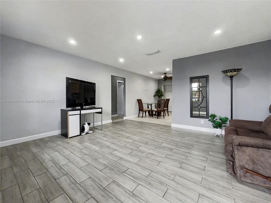 Spacious home featuring No Pop-Corn Ceilings, Updated Kitchen, Modern Recessed lighting and 1-car garage with spacious driveway that accommodates 2 vehicles. Upgrades include a NEW ROOF (2025), AC system (2024), newer appliances, Modern flooring in the living and dining areas, and Newer Windows with SHUTTERS throughout—