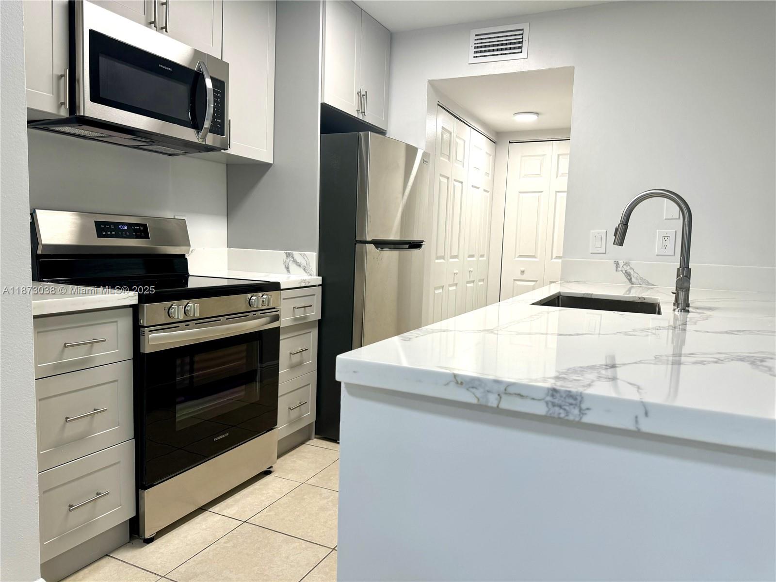 Wow! You will fall in love with this totally remodeled first floor beauty. Gorgeous kitchen with quartz countertops, stainless steel appliances and beautiful bathrooms. Washer & dryer in unit and closets galore. Also a patio and storage room you can keep bicycles in for riding around the 10 miles of lake paths. Tennis court, 2 swimming pools, clubhouse with exercise rooms, kiddie playground and BBQ area all in this gated community. Ejnoy all of the Hammocks amenities, too! Three club houses with pools, basketball courts, tennis courts and activities. Baptist West hospital less than 5 miles away, restaurants, pharmacies, grocery stores, schools and lots of shopping within minutes. A convenient and wonderful place to live in and enjoy! Hurry, won't last!