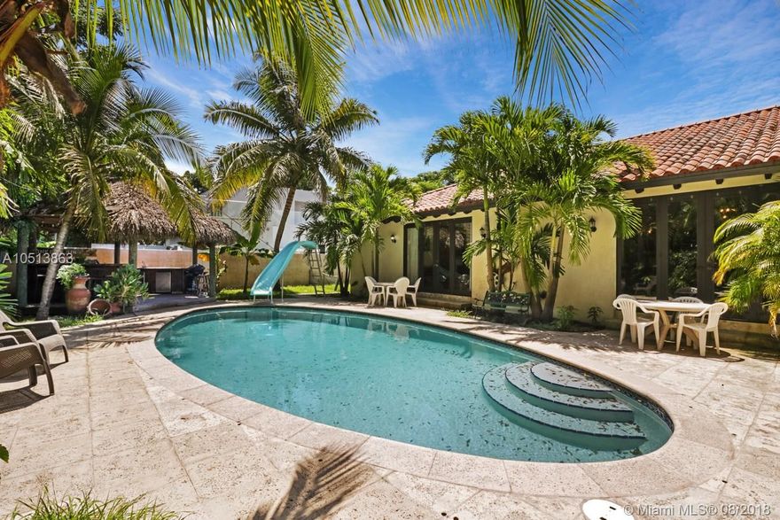 Located in the heart of Coconut Grove, this gated, oversized lot and spacious home offers over 4,000 sf of living area includin 5 bedrooms and 4 bathrooms. Classic villa-style details begin with the arched front doorway and continues to vaulted ceilings with hand-hewn wooden beams and travertine floors in main living areas. Recently remodeled kitchen features solid oak cabinetry, granite and stone countertops, travertine tilework, professional-grade appliances, wine fridge, and open archway that connects to informal family room. Wood flooring and travertine finishes continue in Master suite with large soaking tub and frameless glass shower. All other bedrooms and bathrooms equally well finished. Covered terrace is perfect for entertaining, connects to pool and outdoor bar-and-grill area.