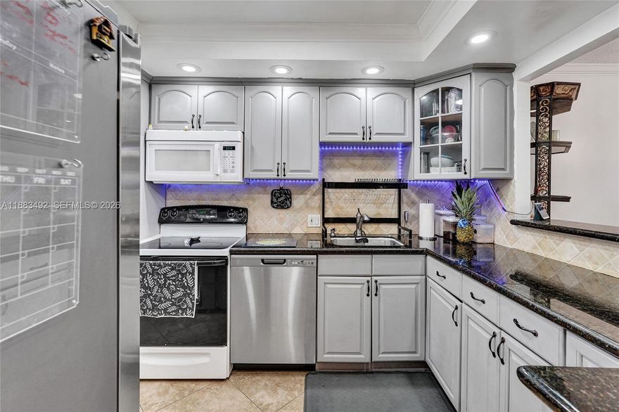 This 3-bedroom 2-bathroom corner home is the largest model in the building, offering a warm and comfortable living space with tons of natural light. Every room feels inviting, with soft sunlight accentuating the crown molding, tile floors, and hurricane-impact windows. Step onto the spacious screened patio and take in one of the finest views in the community, a lush private backdrop of trees and golf course greens. The association is exceptionally strong with reserves well funded and all structural work complete. Enjoy a relaxed lifestyle with resort-style amenities including a pool, golf course, clubhouse, walking paths, and beautifully landscaped grounds, all nestled in the heart of Pompano Beach.