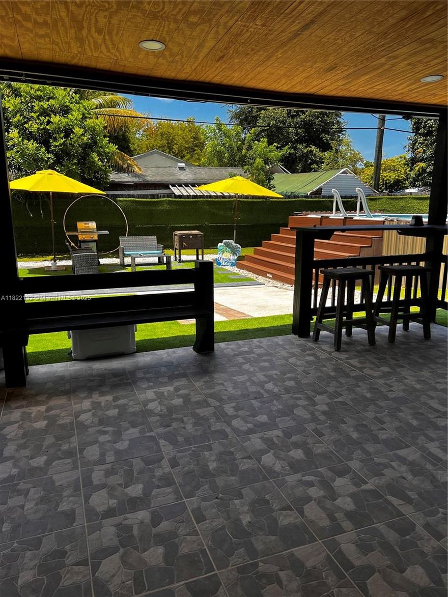 Beautifully maintained 3-bedroom, 2-bath single-family home combining comfort and style. Features a bright open-concept layout with marble-look tile floors throughout. The updated kitchen offers rich wood cabinets, granite countertops, stainless steel appliances, and a built-in beverage cooler. Enjoy a spa-inspired bathroom with sleek finishes, rainfall shower, and frameless glass. The backyard is a true retreat with a covered patio, BBQ area, and an above-ground pool with sun deck, all surrounded by low-maintenance turf and tropical landscaping. Recessed lighting, modern fixtures, and a spacious driveway with room for a boat or RV add to the appeal. Conveniently located near highways, shopping, and schools—perfect for relaxing or entertaining!