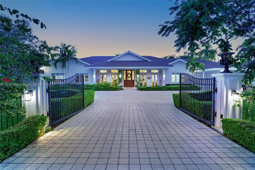 The Hamptons meets Key West in this sophisticated N Pinecrest home on a spectacular acre+ lot! Built in 2017, every detail is perfect. Warm hardwd & marble flrs, beautiful moldings & millwork combine w wonderful natural light thruout the home. The 1-story 6BR/6.5BA home has sep living, dining & family rms, full home generator, two office spaces, impact windows/doors, open & bright kitchen w top of the line appliances. Primary suite features 2 walk-in closets & water closets, soaking tub & spa-like shower. Relax on the picturesque covered patio w summer kitchen, enjoying the magnificent backyard, resort style 45-foot pool, jacuzzi & waterfall. Other features incl 3-car garage, 2-car carport, motorized front gates, smart house wiring & LED lighting. Enjoy mango, avocado & loquat trees too!