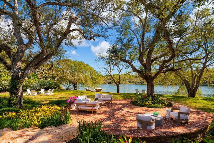 Welcome to an enchanting residence nestled in the prestigious gated enclave of Banyan Drive in Coral Gables. This spectacular lakefront property spans over an acre graced w/majestic oaks. The elevated contemporary architecture w/its new kitchen & baths, warm wood floors, & numerous entertaining spaces, all harmonize w/nature providing a stunning backdrop for daily life. Each room is designed to capture natural light & offer breathtaking views of the water & lush surroundings. Abundant space with the perfect angle for capturing the prevailing winds makes it an ideal setting for both intimate & grand gatherings alike. Experience nature w/early morning swims & sunset Kayak rides. This residence embodies a lifetime of elegance & comfort in a truly unparalleled location. A Very Special Home.