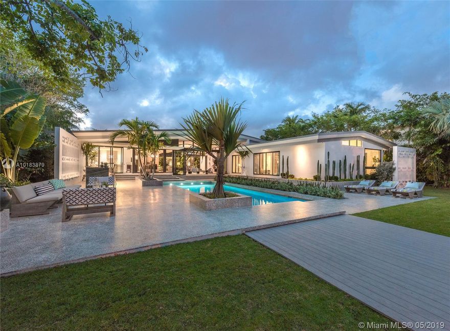 Exceptional Mid-Century Modern masterpiece signifying extravagant Miami Beach lifestyle. Two-year renovation orchestrated by French architect/designer Jean-Louis Deniot. Custom terrazzo floors, vaulted 14 ft ceilings, 2 marble wet-bars, fire feature, total sliding glass doors front & back gives the space a feel of endless fluidity. Modern kitchen, Wolf & SubZero, Dornbracht, Waterworks, Lutron, security cameras, heated pool, new dock, seawall are few of the features of this spectacular home w/ 100 ft WF.