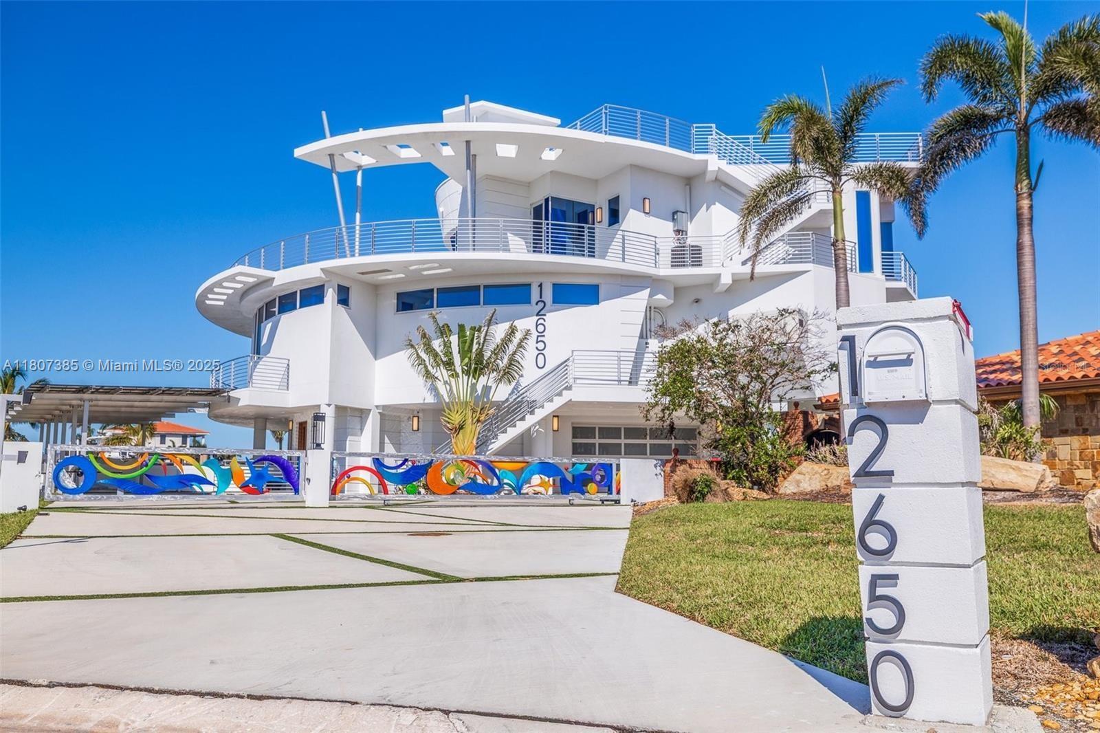 Exceptional 6,428 sq ft all-concrete smart home offering refined waterfront living. Features include a 4-story glass elevator, Kevlar-reinforced impact windows, 71 solar panels, 48kW generator, 4 zoned 5-ton heat pumps, and smart automation throughout. Resort-style outdoor space boasts a 40,000-gallon pool with beach entry, jacuzzi, LED lighting, and outdoor kitchen, plus two vehicle turntables. A 265-ft raised seawall with 36" concrete cap leads to a 2025 dock with water, electric, and 40,000 lb lift, accommodating yachts up to 135’ with a 20’ beam. Built for luxury, innovation, and resilience in every detail.