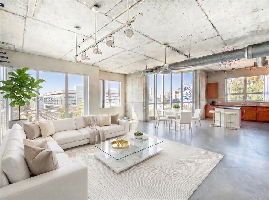 Top-floor corner unit at Cite on the Bay in Edgewater — 2 bed, 2 bath, 1,351 sq ft with 12-ft ceilings and floor-to-ceiling impact windows framing unobstructed sunset views over Biscayne Bay. Open-concept living flows to a private balcony, new AC and water heater, and short-term rental eligibility (30-day min). Steps from Margaret Pace Park, minutes to Wynwood, the Design District, and Downtown via I-95.