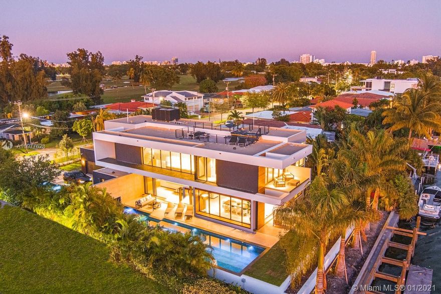 Villa "L'Artiste" is a modern estate that sits in a quiet gated community encompassing the famous Normandy golf club and brand new tennis center. The property broadcasts 5 bedrooms with 5 en-suite bathrooms and 1 powder room.Boasting opulence and sophistication with design by Togu, the main level of the home provides a fully equipped kitchen with Miele appliances, a 22 foot bianquissimo quartz countertop, 20 ft high soaring ceiling and a 20 ft long LED Chandelier across the living area.  A 500 sqft Rooftop overlooks the Golf course, the canal and the Bay. Full size sliding doors lead to a 55 foot long boat dock and oversized heated pool prolonged by a decorative 40ft pond. Finally, Villa "L'Artiste" is staged by Meredith Baer with Modern furniture to boast luxurious indoor-outdoor living.