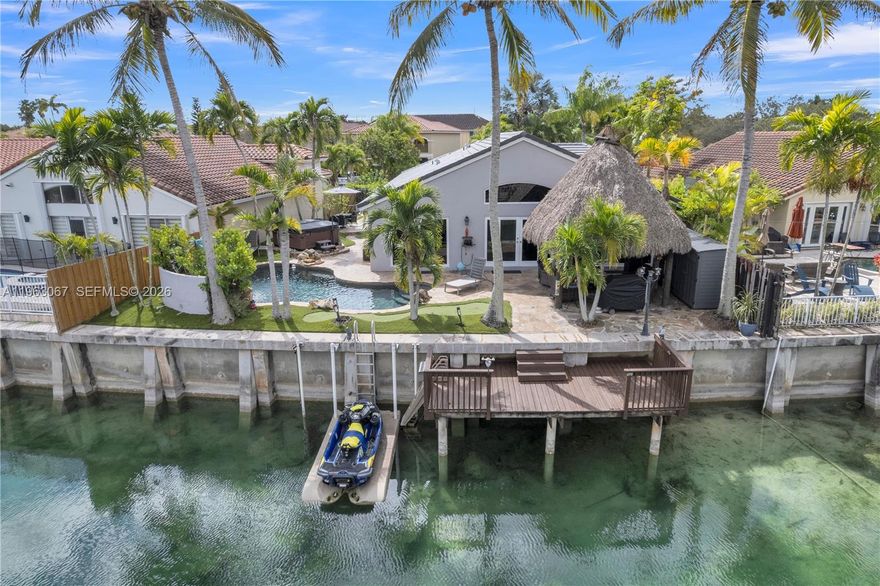 Rare opportunity in the highly sought-after, guard-gated Three Lakes community of West Kendall, prized for its boat & jet ski friendly 100+ acre lake—one of the few of its kind in Kendall. This 3/2 waterfront home sits on an interior canal with direct lake access & features a private wooden dock plus a floating dock for personal watercraft, while the community also offers a dock & boat ramp for shared use. Enjoy resort-style outdoor living with a lagoon-style rock waterfall heated pool, 7-person hot tub, an entertaining Tiki Hut and a low-maintenance putting green. Backyard features deluxe artificial turf creating a clean, easy-care space ideal for relaxing or entertaining. Plumbed ready for a future outdoor 3rd bath, offering added flexibility for outdoor living. Major improvements include a 2025 flat tile roof, New hurricane-impact windows & doors ,reinforced attic roof rafters, hurricane-rated garage door, & newer hot water heater—providing peace of mind & insurance savings. Ideally located near abundant shopping, dining, and everyday conveniences. Interior features travertine tile in main living areas, deluxe blinds, LED lighting, upgraded kitchen with induction range, hi tech refrigerator, whole-house water filtration & reverse osmosis system. HOA includes 24/7 security gates, clubhouse, fitness center, community pool, tennis, pickleball, and lake access. Come experience the waterfront lifestyle that makes Three Lakes one of West Kendall’s most desirable communities.