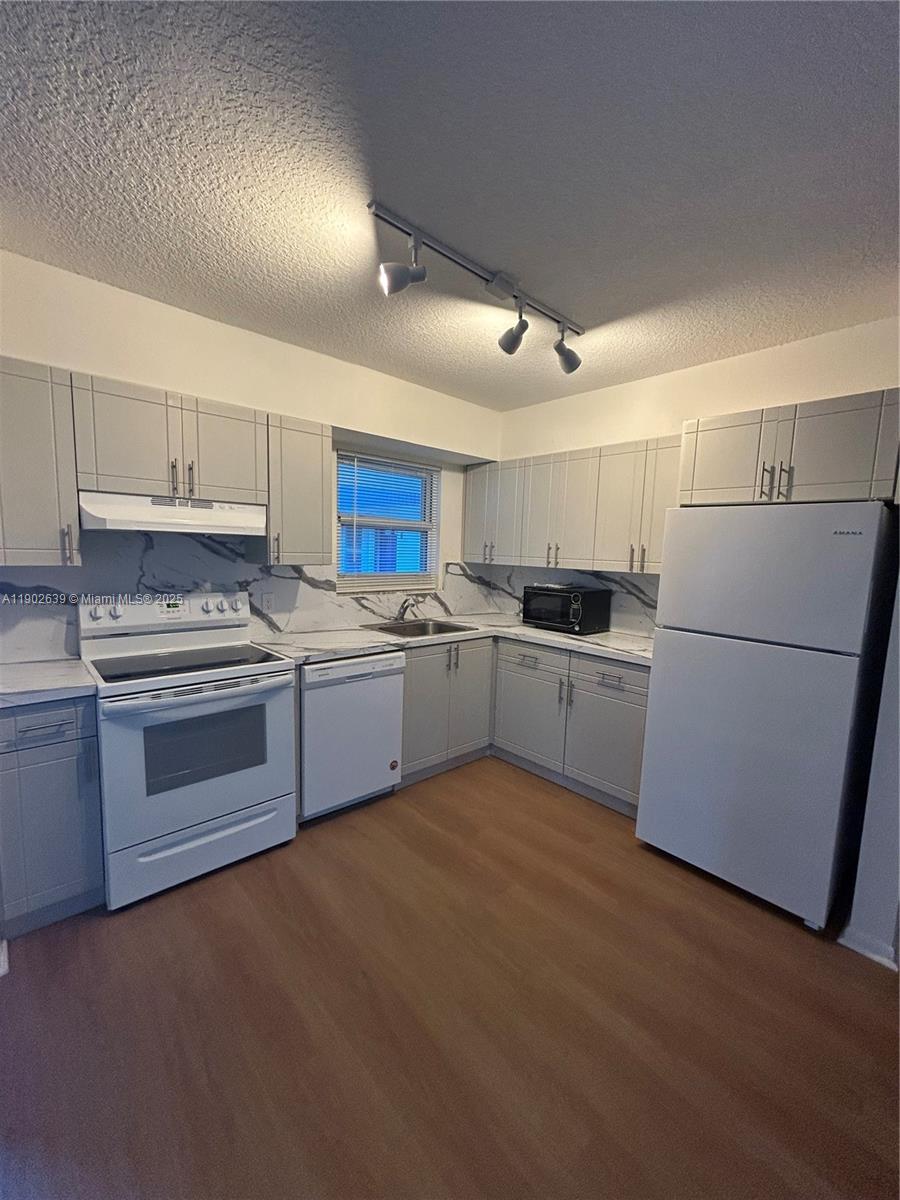 Cozy 2BR/2BA with bay views, wood-style floors, laundry steps away, prime Dania Beach location, peaceful and inviting.