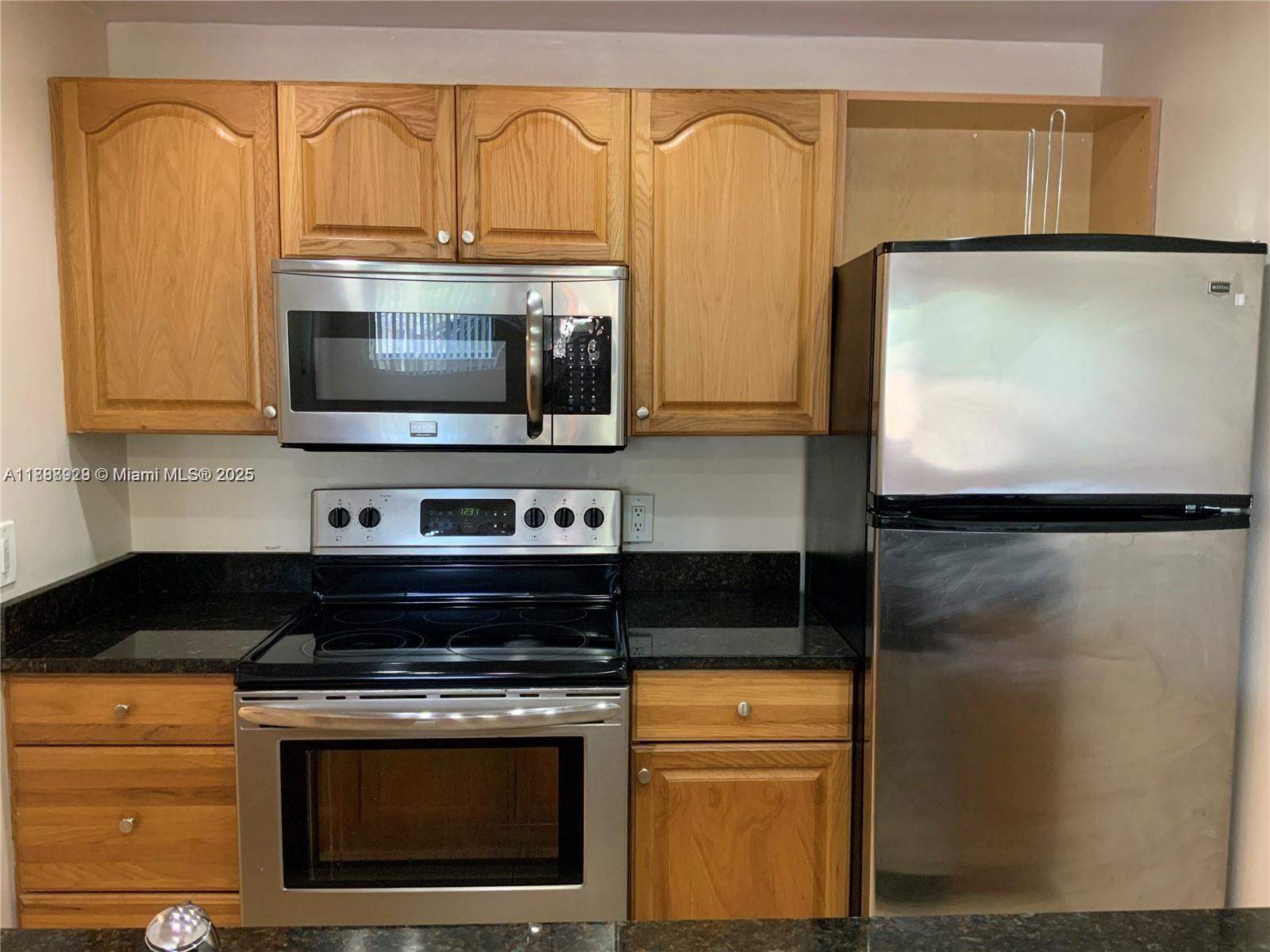 his lovely one-bedroom corner unit features granite tops, stainless steel appliances, wood cabinets, laminated flooring, a large walk-in closet, an inside washer/dryer, and a tankless water heater. The open balcony offers a pleasant and relaxing view of the main pool and green area.