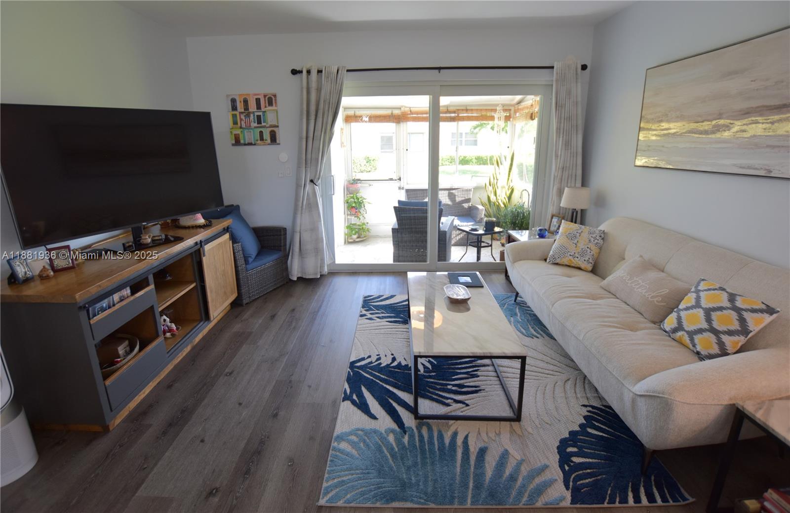 This unit is sure to impress! Fully updated with modern kitchen, bathrooms, and flooring, plus an AC unit that's less than a year old. All openings feature impact glass, including the slider. The open kitchen boasts a sleek island set off to the side. Enjoy the enclosed patio and a second paved patio just outside. There's also a full pantry, a linen closet, and an extra storage closet on the patio.