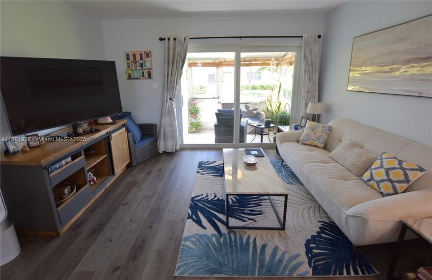This unit is sure to impress! Fully updated with modern kitchen, bathrooms, and flooring, plus an AC unit that's less than a year old. All openings feature impact glass, including the slider. The open kitchen boasts a sleek island set off to the side. Enjoy the enclosed patio and a second paved patio just outside. There's also a full pantry, a linen closet, and an extra storage closet on the patio.