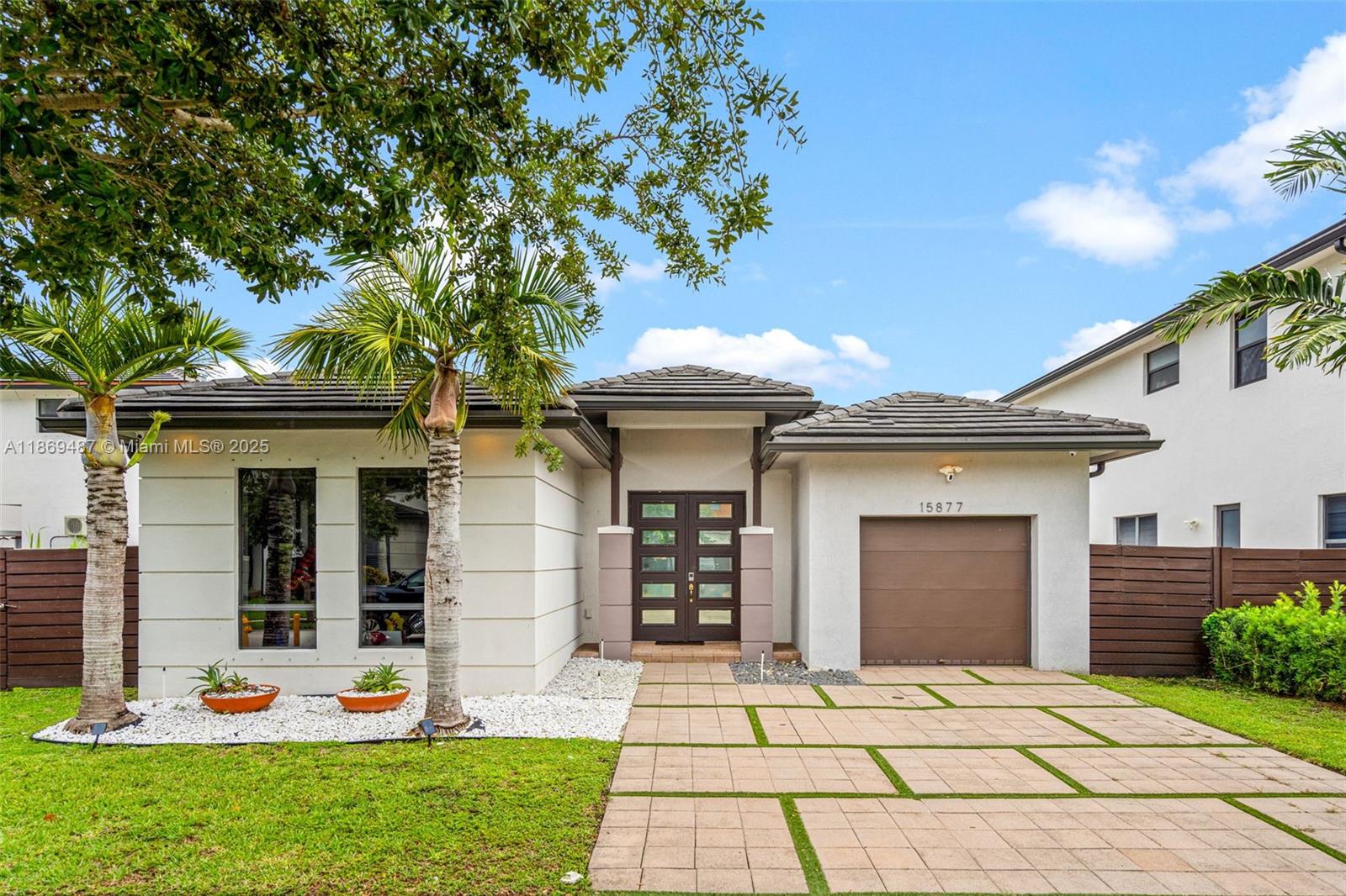 Welcome to this stunning 3-bedroom, 2.5-bath single-family home nestled in one of West Kendall’s most sought-after modern suburban communities. Boasting 2,000 sq ft of beautifully designed living space, this residence blends luxurious design with everyday comfort. Step inside to soaring 10-foot ceilings, a striking marble fireplace, and a custom wooden slat and full mirrored feature wall in the entryway—creating an immediate sense of space and sophistication. A custom-designed laundry room leads directly to the garage, adding both functionality and style. Enjoy the peaceful surroundings of a tranquil community offering walking trails, a meditation garden, lush landscaping, and a children’s playground—all just steps from your front door.