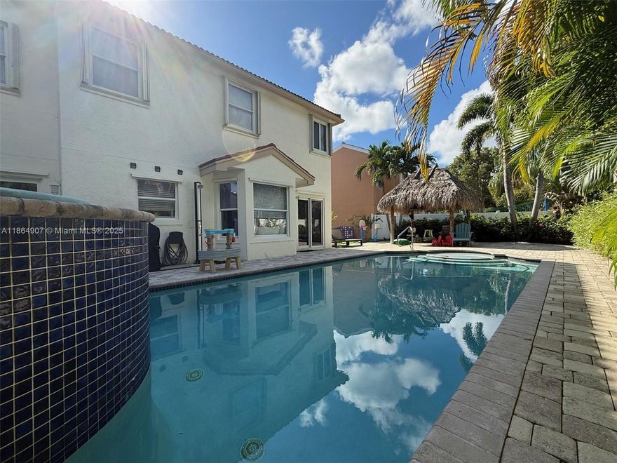 Welcome to your private South Florida Oasis- with a heated saltwater pool with a waterfall, an oversized lot, an outdoor shower and amazing Tiki hut for shade and privacy! 2 car garage, and everything you need for a comfortable lifestyle. 3 bedroom + 2.5 bathrooms, upstairs den has been converted into a 4th bedroom, plus an office space downstairs with sliding glass doors that can be used as a guest bedroom. Large custom-built walk-in closet in the master bedroom plus another walk-in closet in the guest bedroom. Hurricane shutters. Nautica gated community has a low HOA fee and offers a heated pool, clubhouse, gym, tennis, basketball, pickleball courts and social events. A must see!