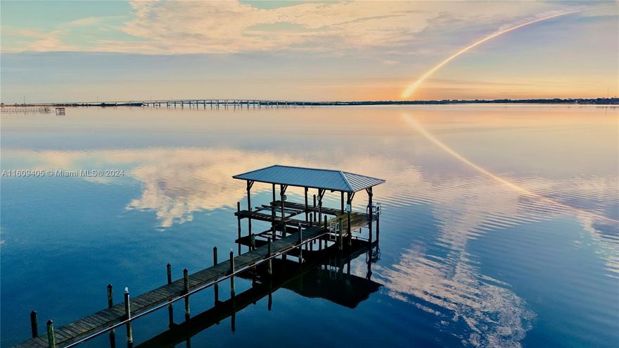 Breathtaking panoramic views, gorgeous custom-built waterfront home on Intercoastal Waterway. Unbelievable location, watch rocket launches w/unobstructed views. Multiple balconies, enjoy tranquil sunrises. Perfect for Florida's luxury lifestyle & ideal for boating enthusiasts! 100 feet of water frontage, boat house w/lift, guest cottage w/loft & 5 car garage. Grand entrance w/soaring ceilings & natural light. The heart of this home is a gourmet kitchen w/stone countertops, gas cooktop & center island. Lower level has a bedroom w/ensuite & home office w/view; upper level includes an add'l living space, 2 bedrooms w/ensuites & spacious master retreat w/picturesque view. Safety meets style, built green, beyond 2014 hurricane code, impact windows/doors & metal roof.