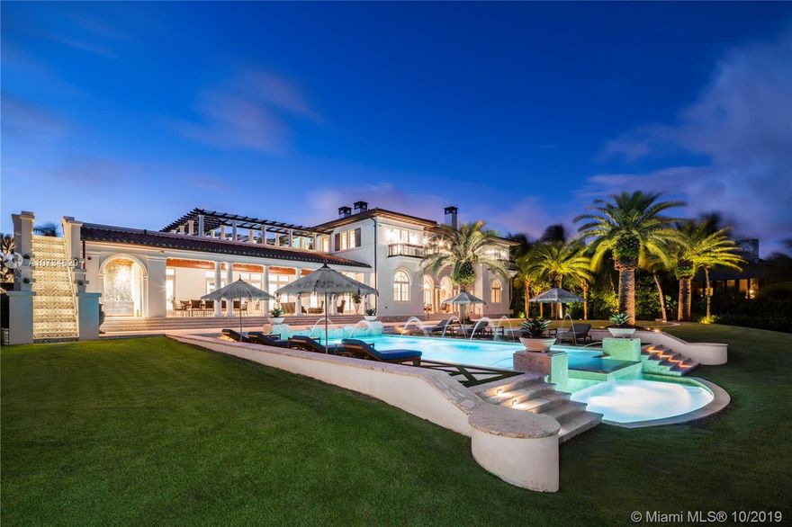 This majestic Tuscan-inspired villa, designed by Rafael Portuondo with the finest finishes and smart technology, is situated on 62,000 SF in prestigious Gables Estates. It boasts 200 ft directly on Biscayne Bay, plus 200 ft on a protected inlet with private dock and boatlift. An entry foyer with marble staircase leads to formal living room and adjacent office. Gourmet kitchen comes with two marble islands. Family room has wet bar in Macassar wood, and wine room has 2,200 bottle capacity. Grand primary suite on second floor has morning bar, two custom closets, and sophisticated primary bathroom. Covered patio includes a summer kitchen and sitting area overlooking an infinity pool with a waterfall. Truly a unique property in a spectacular setting, with wonderful breezes off the Bay.