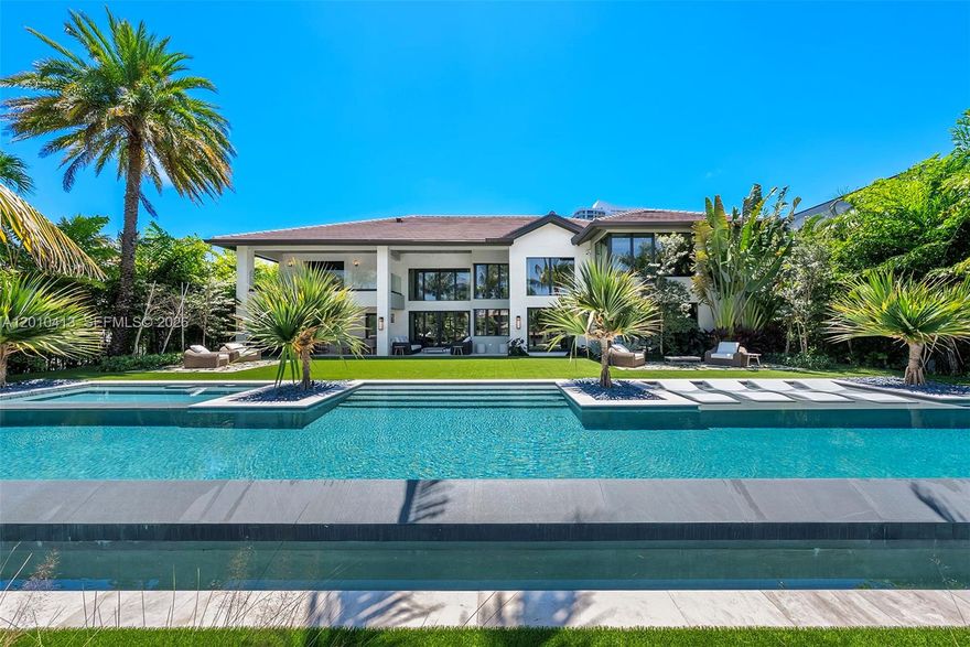 Welcome to 110 Holiday Dr in Golden Isles, a tropical modern estate curated by Pietra Casa Studio in one of South Florida’s most central waterfront neighborhoods. This sprawling residence is perfectly positioned on the lot, with soaring ceilings, a seamless family layout, and an 80 ft resort-style pool that anchors the outdoor living. Warm, bold design is expressed through white shell limestone, Tundra Grey marble, and rich natural textures throughout. Interiors feature Italian marmorino plaster, bespoke oak and marble furnishings, handmade lighting, and a Mia Cucina kitchen with Inalco slabs, SubZero and JennAir appliances. A fully realized design experience, inside and out.