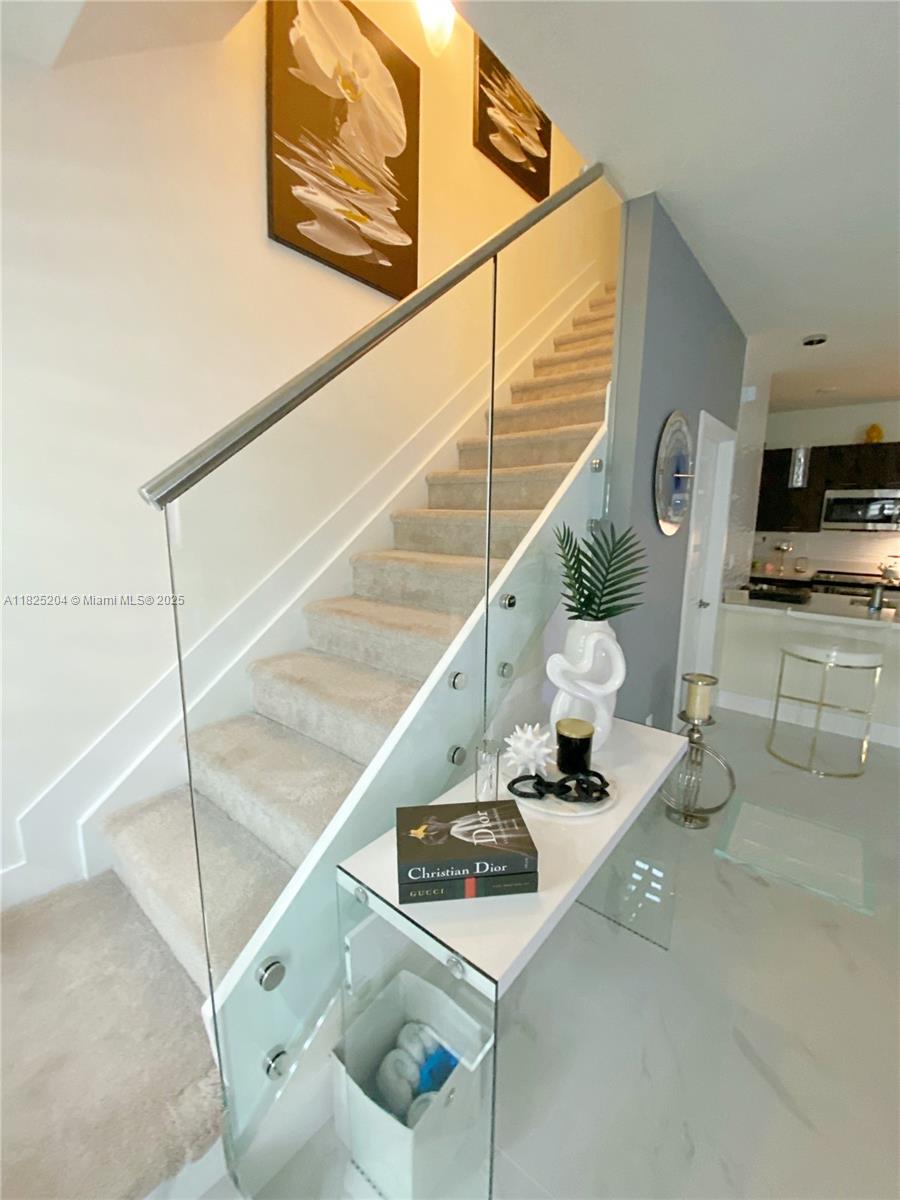 Stunning 3-story townhouse in the prestigious Urbana community of Downtown Doral, built in 2020 with modern elegance and superior craftsmanship. This 3-bedroom residence features 2 full baths, 2 half baths, an upgraded gourmet kitchen, sleek flooring on the first level, and a striking glass stair railing. The spacious rooftop deck with a summer kitchen offers the perfect retreat for outdoor entertaining. A luminous and open floor plan seamlessly blends style and functionality, while the indulgent master suite provides a serene escape. Enjoy unparalleled access to upscale shopping, fine dining, top-rated schools, and world-class entertainment in the heart of Doral.
