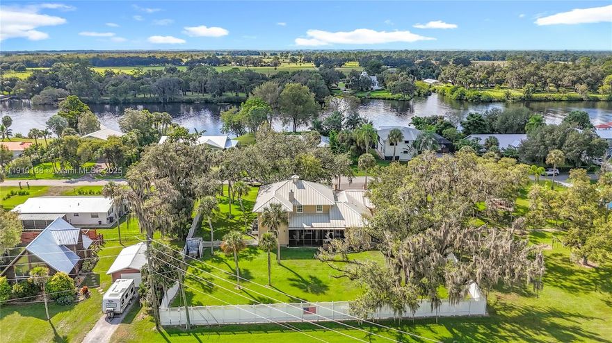 CUSTOM, CUSTOM 4 BEDROOM 3.5 BATH + APARTMENT. Welcome to this stunning two-story concrete block home, enhanced with cement board exterior facade, nestled on a spacious .55-acre double lot along CR 78, with easy access to Alva, LaBelle, SR 80, and Fort Myers. Custom built in 2005 and professionally repainted in 2022, this 6,000+/- sq. ft. residence (3,310 sq. ft. under air) combines timeless craftsmanship with thoughtful modern upgrades. Inside, rich solid wood floors, beautiful stone fireplace, and custom wood blinds set an inviting tone. The primary suite is conveniently located on the main floor with a private slider opening to the screened lanai. The formal dining room adds elegance, while the open great room and kitchen create the perfect family gathering & entertaining space.
