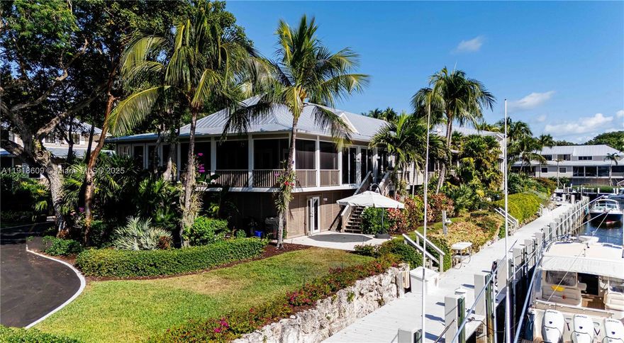 Set within the private gates of the Key Largo Anglers Club, this beautifully renovated cottage captures the essence of refined Keys living. Sweeping sunset views stretch down the canal toward Card Sound Bay, and a nearby dock accommodates a boat up to 42 feet—perfect for effortless days on the water. The residence features three bedrooms and three baths, anchored by a contemporary kitchen with custom cabinetry, quartz surfaces, Jenn-Air and Bosch appliances, and a dedicated wine cooler. The primary suite is a serene retreat, offering a spa-style bath with double marble vanities, a large walk-in shower, generous closets, and an adjoining study ideal for an office or private lounge. Each guest bedroom includes an en-suite bath for comfort and privacy. Soaring ceilings, porcelain tile flooring, and a screened patio with electric roll-down sunshades create seamless indoor-outdoor enjoyment. Below, expansive covered parking provides space for vehicles and golf carts, along with abundant storage and a workshop. Framed by manicured tropical landscaping and vibrant orchids, this fully furnished home is move-in ready—a rare blend of elegance, ease, and true Keys charm.