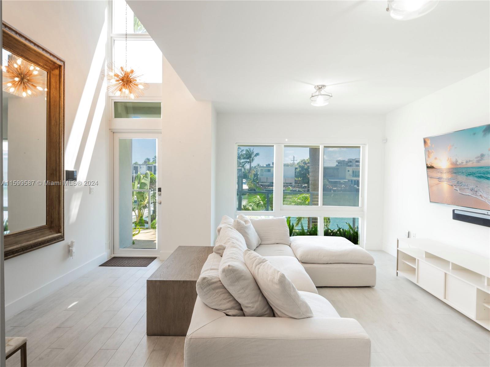 This rarely available fully furnished waterfront townhouse with stunning water views is nestled in a gated community surrounded by a lush landscaped waterfront promenade, tennis courts, The Normandy Shores Golf Club, and just moments from Miami Beach and Bal Harbour. Featuring an elevator, and a 2 car garage, the first floor enjoys a stunning double-height entrance and a spacious living room. The second floor boasts a modern kitchen, a beautiful light-filled dining room, a laundry room, and a guest bathroom. The third floor has two large bedrooms each with ensuite bathrooms, built-out closets, and private balconies. The last floor has the modern primary suite overlooking the serene rooftop terrace with picturesque canal views. This townhouse epitomizes elegance and modern luxury living!